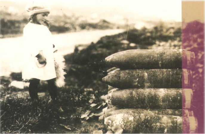 Fillette fixant une pile d’obus d’artillerie lourde, vers 1920, Chavignon (Aisne). Archives départementales de l’Aisne, cote FRAD002
